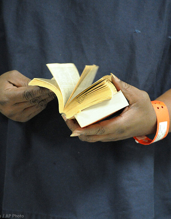 An incarcerated person thumbs through a book