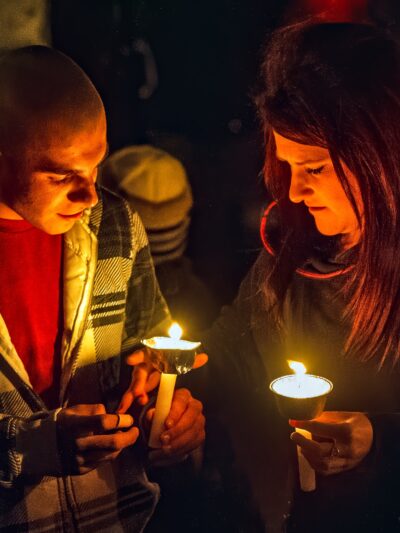 Two people holding candles at a vigil