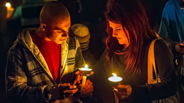 Two people holding candles at a vigil