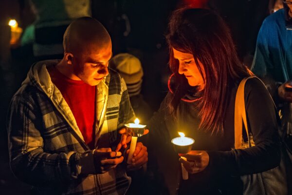 Two people holding candles at a vigil