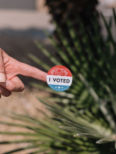 Hand with I Voted sticker