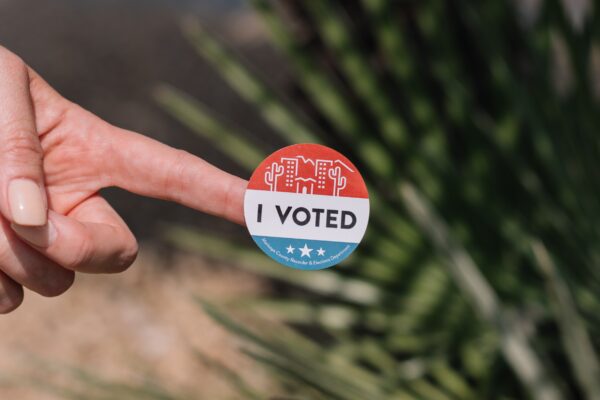Hand with I Voted sticker