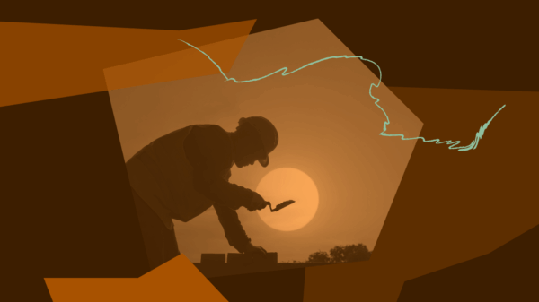 A silhouette of a worker laying bricks in the sun.