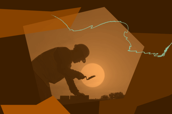A silhouette of a worker laying bricks in the sun.