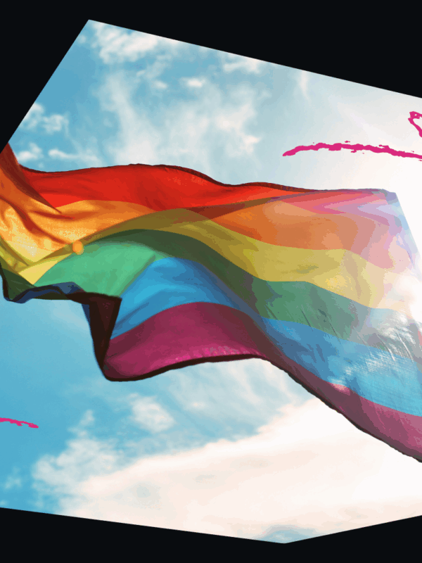 LGBTQ+ Flag flying on a clear, sunny day.