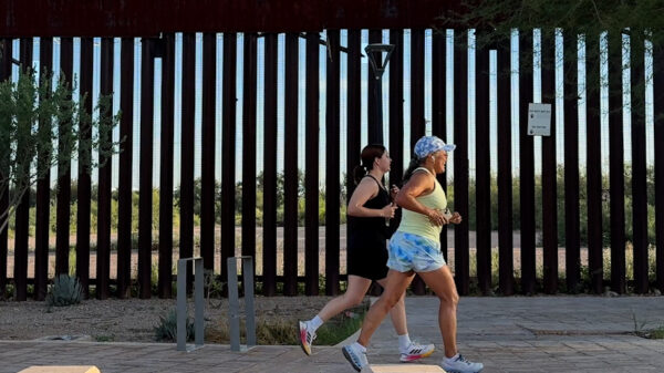 two women running along the U.S.-Mexico border.