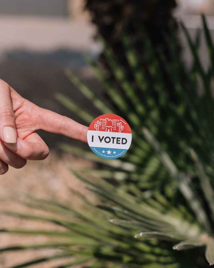 Hand with I Voted sticker