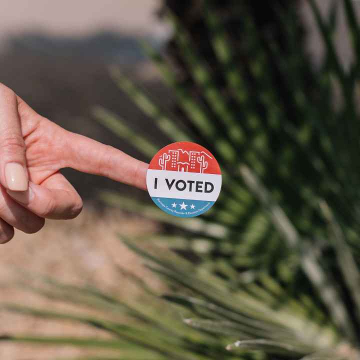 Hand with I Voted sticker